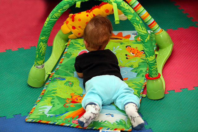 bebê deitado em tapetinho infantil