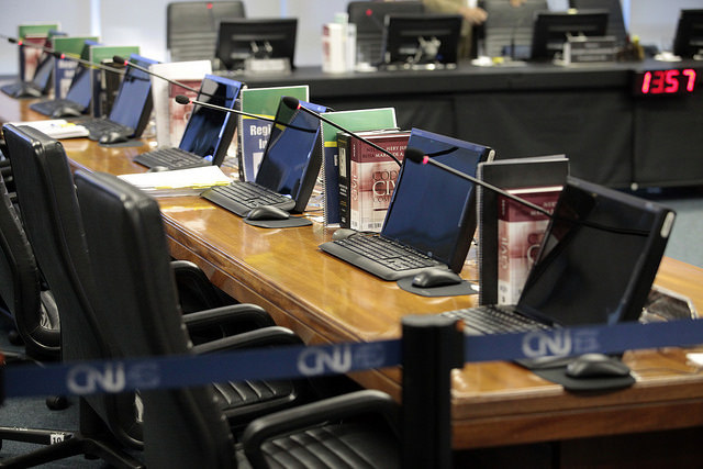 Foto de notebooks abertos nas bancadas do Plenário do CNJ, que está sem pessoas presentes.