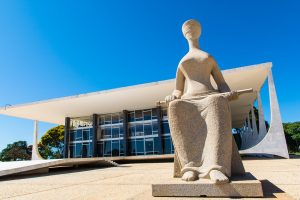 Foto da fachada do Supremo Tribunal Federal (STF), com destaque à estátua à frente do prédio