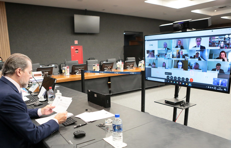 Foto da 315ª Sessão Ordinária do Conselho Nacional de Justiça (CNJ), realizada em 4 de agosto de 2020, com o ministro Dias Toffoli comandando em frente à tela de videoconferência onde aparecem os demais conselheiros do CNJ