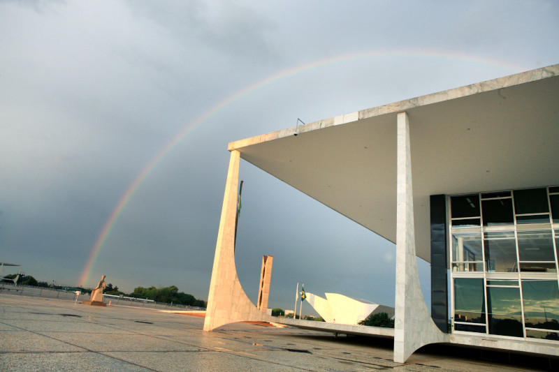 Foto da fachada do Supremo Tribunal Federal (STF) com arco-íris ao fundo.