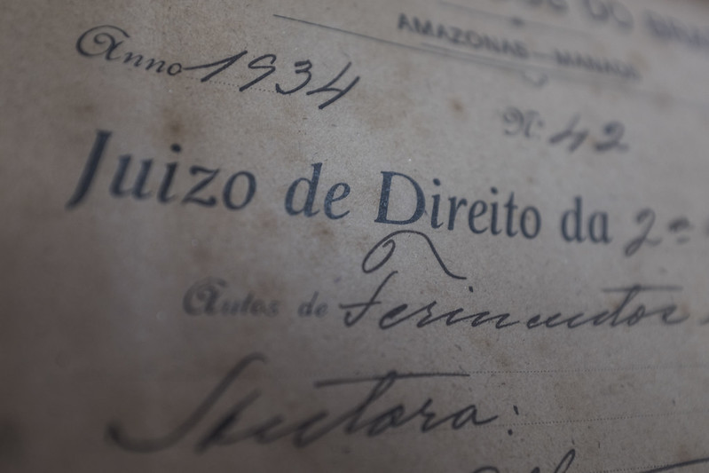 Foto em preto e branco mostra detalhe de um documento judicial antigo, datado de 1934, época em que os autos ainda eram preenchidos de forma manuscrita.