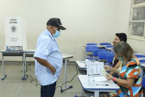 Foto de eleitor e mesários em seção eleitoral durante as Eleições Suplementares de Açorizal (MT), em 1º de agosto de 2021.