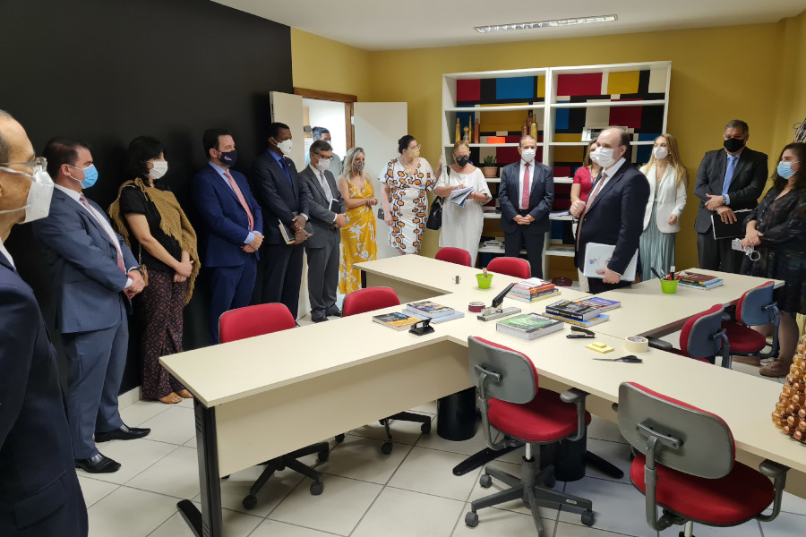 Foto mostra pessoas do TRE-ES dentro da sede do Laboratório. Ao centro, o presidente do Tribunal apresenta o espaço físico.