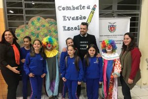 Foto mostra o juiz Carlos Eduardo Mattioli Kockanny posando para foto com crianças atendidas pelo projeto Combate à Evasão Escolar.