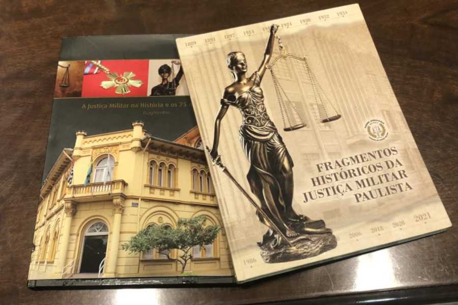 Foto mostra as duas edições do livro em uma mesa de madeira.