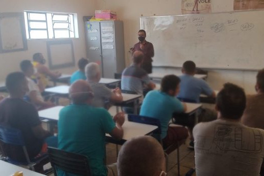 Foto de sala de aula em unidade prisional no Piauí, com diversos presos sentados assistindo a uma aula.