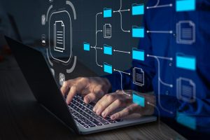 Arte mostra as mãos de um homem digitando em um notebook e, cobrindo o corpo dele, grafismos representando solução tecnológica.
