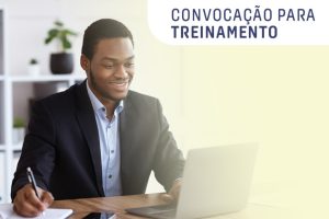 Foto mostra um homem negro sorrindo, sentado em frente a um notebook. Texto: Convocação para Treinamento.