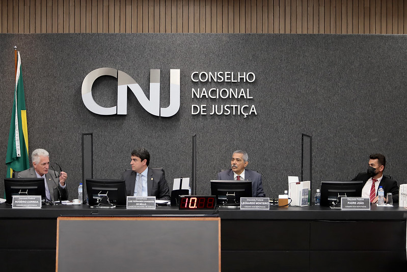 Foto mostra bancada do plenário do CNJ, com os três deputados federais e o conselheiro do CNJ sentados durante a reunião. O deputado Rogério Correia, à esquerda, está falando, enquanto os demais olham para ele.