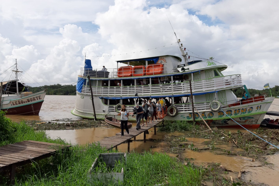 Foto mostra pessoas descendo do barco que faz o transporte das equipes durante a Jornada Fluvial.