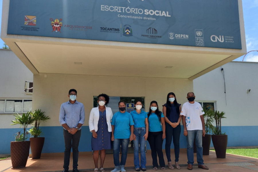 Foto mostra a equipe do Escritório Social de Palmas posando em frente à unidade.