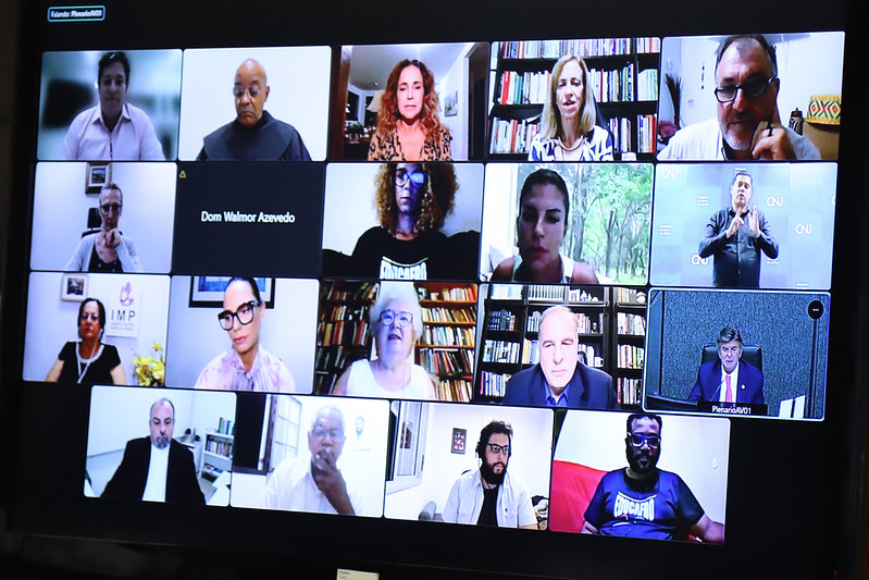 Foto mostra telão com participantes da reunião por videoconferência.