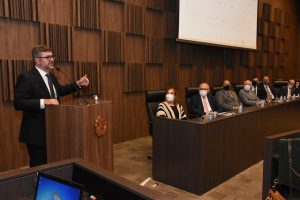 Foto mostra secretário-geral do CNJ em um púlpito falando com os representantes dos tribunais mineiros presentes à reunião.