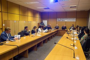 Foto mostra momento da reunião, com participantes sentados em mesa em U em sala do TJRJ.