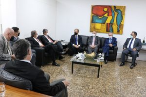 Foto mostra momento da reunião com participantes sentados em sofá em uma sala do TJES.