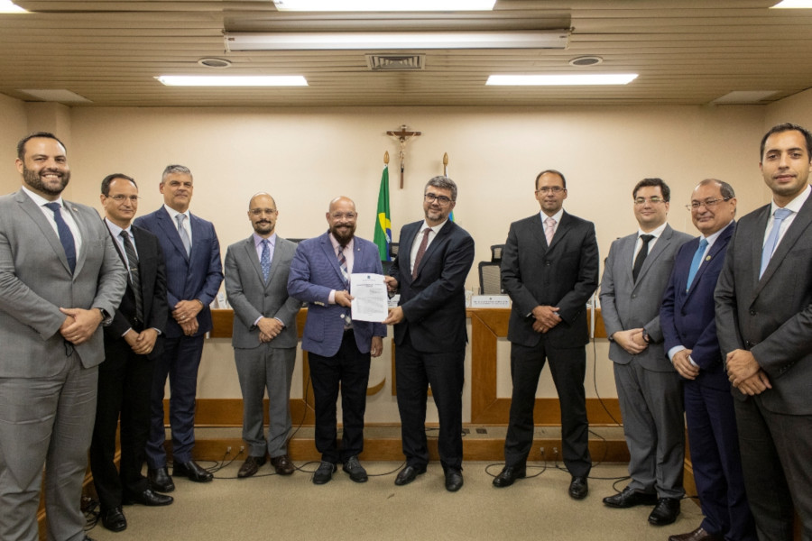 Foto mostra pessoas participantes da reunião em pé, no plenário do TJAP, posando para a foto.