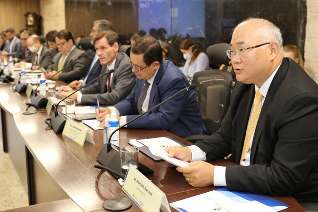 Foto mostra bancada lateral do plenário do TJGO, com destaque ao conselheiro do CNJ, Richard Pae Kim, falando durante o evento.