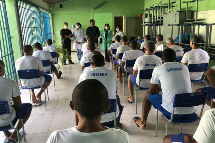 Foto dos presos em uma sala de aula dentro da penitenciária. Na frente da sala, estão, em pé, cinco pessoas que ministraram a atividade.