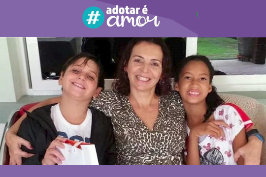 Sobre fundo roxo, com a logomarca #AdotarÉAmor, foto da servidoras abraçada e sorrindo com o filho e a filha adotiva.