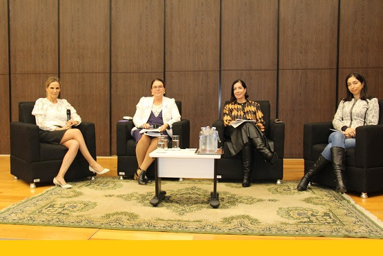 Foto mostra as quatro debatedoras sentadas em poltrona no palco de auditório.