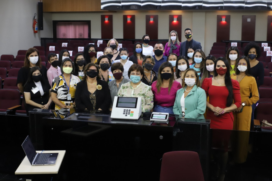 Foto mostra pessoas participantes do evento, em pé, no Plenário do TRE-PA.