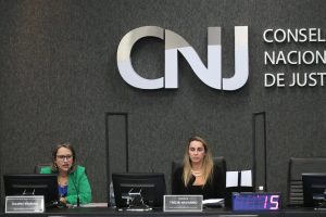 Foto mostra, na bancada principal do Plenário do CNJ, a secretária nacional de Atenção à Primeira Infância do Ministério da Cidadania, Luciana Siqueira, sentada à esquerda da foto e a juíza auxiliar da Presidência do CNJ Trícia Navarro, sentada á sua direita.