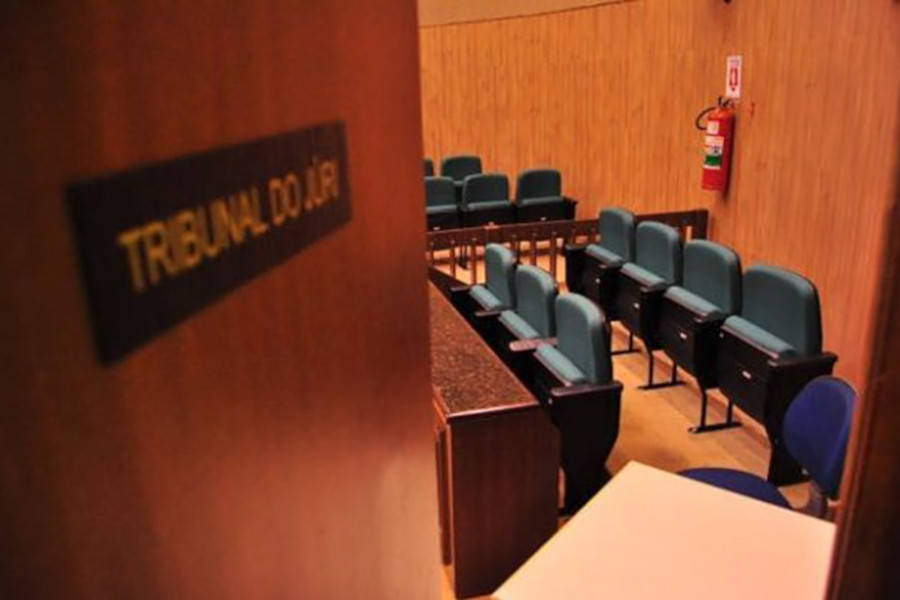 Foto de área interna de salão do Tribunal do Júri vista da porta.