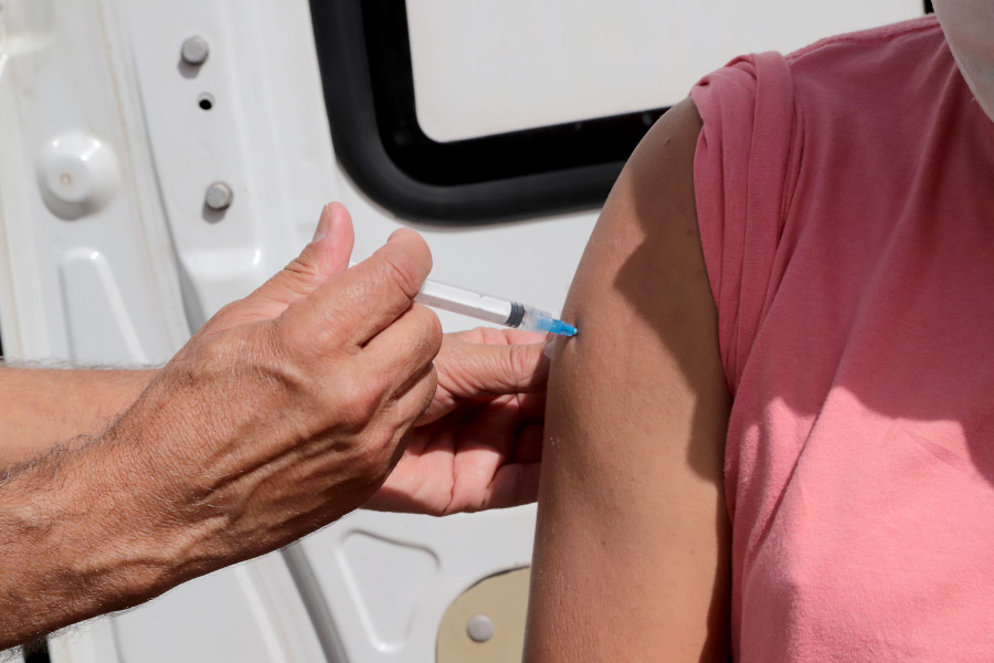 Foto mostra o detalhe do braço de uma pessoa recebendo a aplicação de vacina.