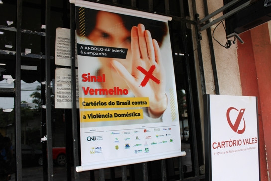 Foto mostra cartaz da campanha Sinal Vermelho na porta de um cartório.