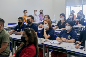 Foto mostra pessoas em sala de aula acompanhando a formação.