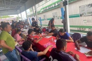 Foto mostra local do projeto com dezenas de pessoas sendo atendidas pelas equipes. Ao fundo, vê-se o barco da Unidade Básica de Saúde.