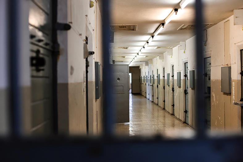 Foto de corredor interno de prisão no Espírito Santo, vista por detrás de barras de ferro