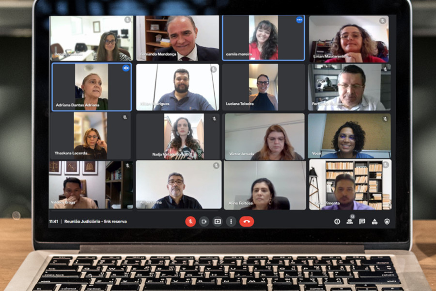 Foto mostra um notebook em uma mesa e na tela se vê momento da reunião por videoconferência.