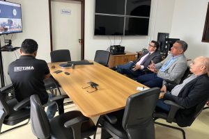 Foto mostra magistrados do TJMA em uma sala conversando com os demais participantes por videoconferência, em um monitor.