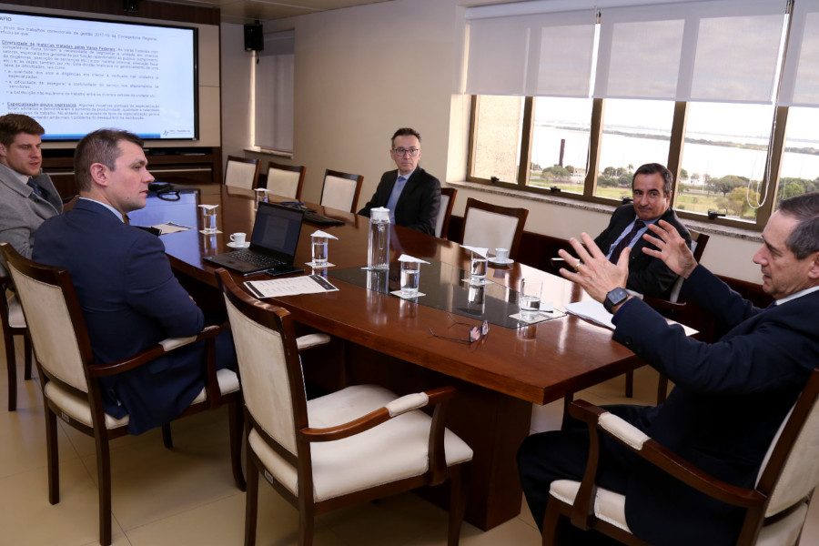 Foto mostra cinco homens sentados em volta de uma mesa durante a apresentação do projeto.