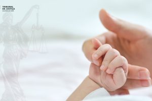 Foto mostra a mão de um bebê segurando a mão de uma pessoa adulta.
