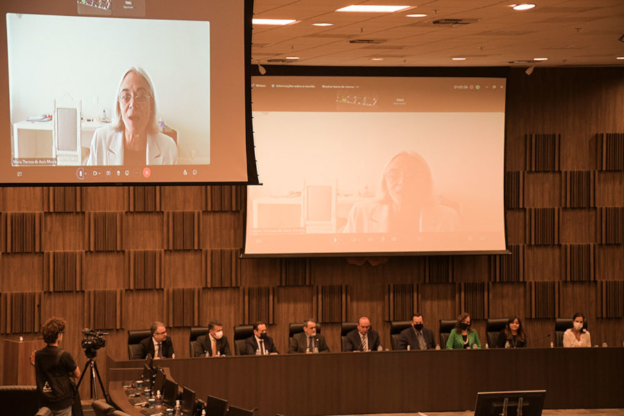 Foto de momento do encerramento da inspeção, com a bancada principal no Plenário do TJMG e ministra Maria Thereza participando por videoconferência em dois telões ao fundo.