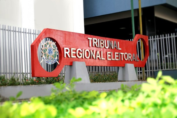 Foto mostra entrada da sede do Tribunal Regional Eleitoral do Amapá (TRE-AP), com destaque à placa com o brasão e nome.