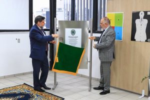 Foto mostra o ministro Caputo Bastos e o presidente do TRT12, José Ernesto Manzi, em pé e retirando o tecido que cobre a placa inaugural do Centro de Treinamento.