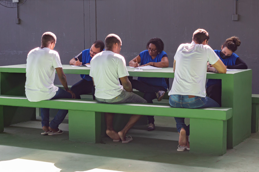 Foto mostra internos sendo atendidos pela equipe do Justiça Itinerante nos Presídios.