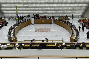 Foto de visão geral do Pleno do STJ, com ministros e ministras sentados em uma grande bancada em círculo.