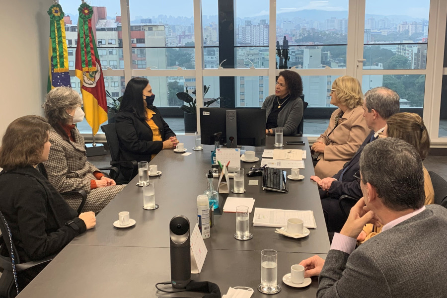 Foto mostra momento da reunião com a conselheira, a presidente do TJRS e outras pessoas participantes em sala do TJRS.