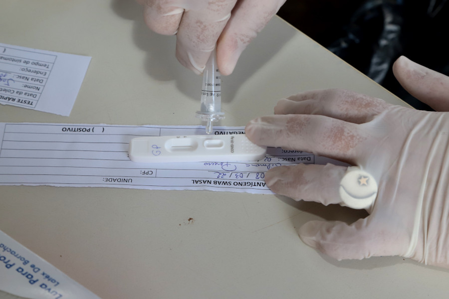 Foto mostra o detalhe de um teste de Covid-19 sendo feito pelas mãos de um enfermeiro.