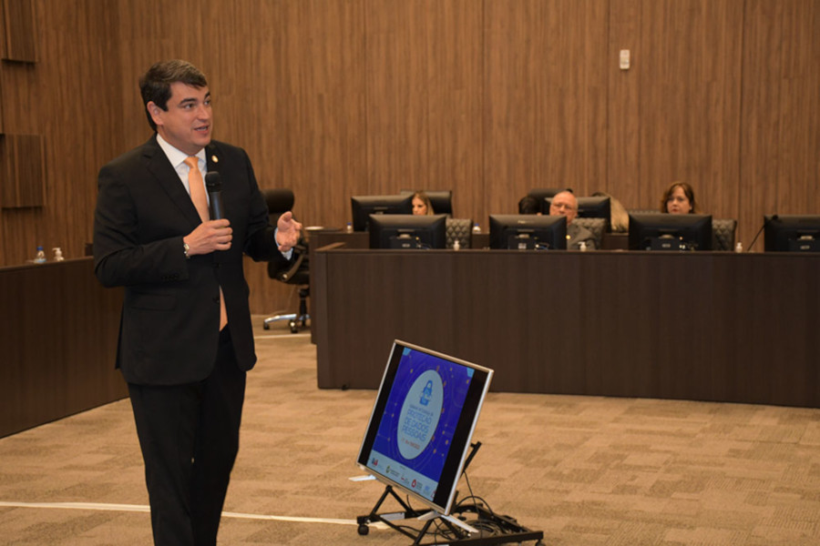 Foto mostra o conselheiro do CNJ Bandeira de Mello no meio do Plenário do TJMG fazendo sua apresentação.