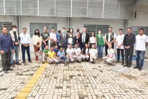 Foto mostra pessoas posando para foto em unidade da Operação Acolhida em Paracaima (RR).