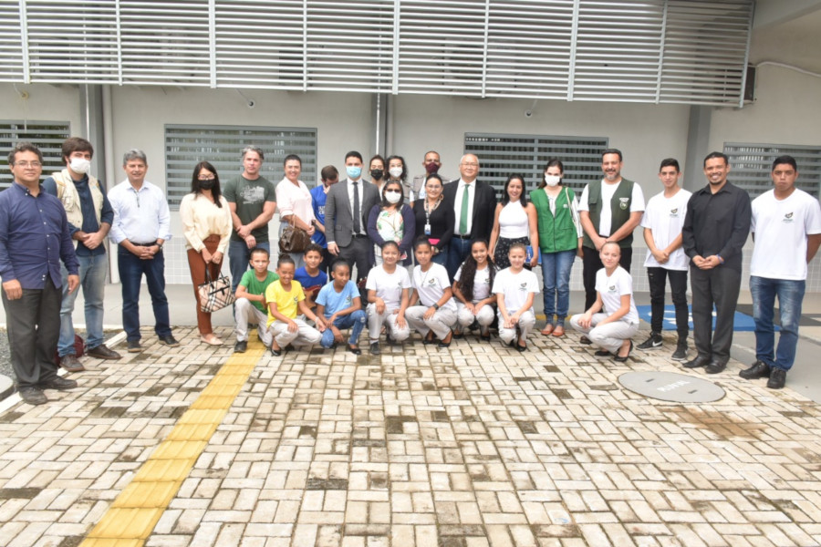 Foto mostra pessoas posando para foto em unidade da Operação Acolhida em Paracaima (RR).