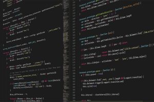 Foto mostra monitor de computador com código em Python na tela.