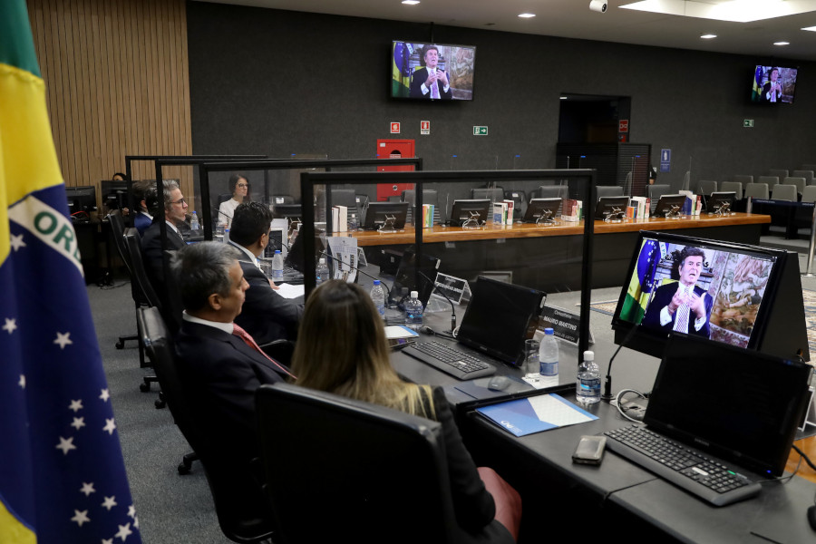 Foto mostra momento da abertura do encontro, no Plenário do CNJ, com participantes da bancada principal assistindo ao vídeo do ministro Luiz Fux em um telão à frente deles.