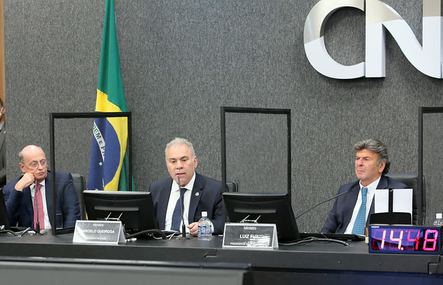 Foto mostra, sentados na bancada principal do Plenário do CNJ durante a cerimônia, da esquerda para a direita: Giovanni Guido Cerri; ministro da Saúde, Marcelo Queiroga; e presidente do CNJ, ministro Luiz Fux.
